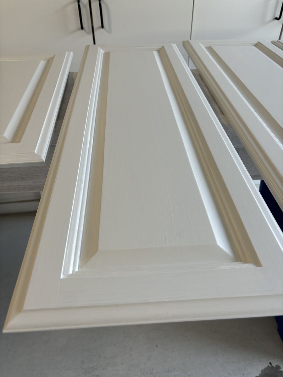 Close-up of freshly painted white raised-panel cabinet door