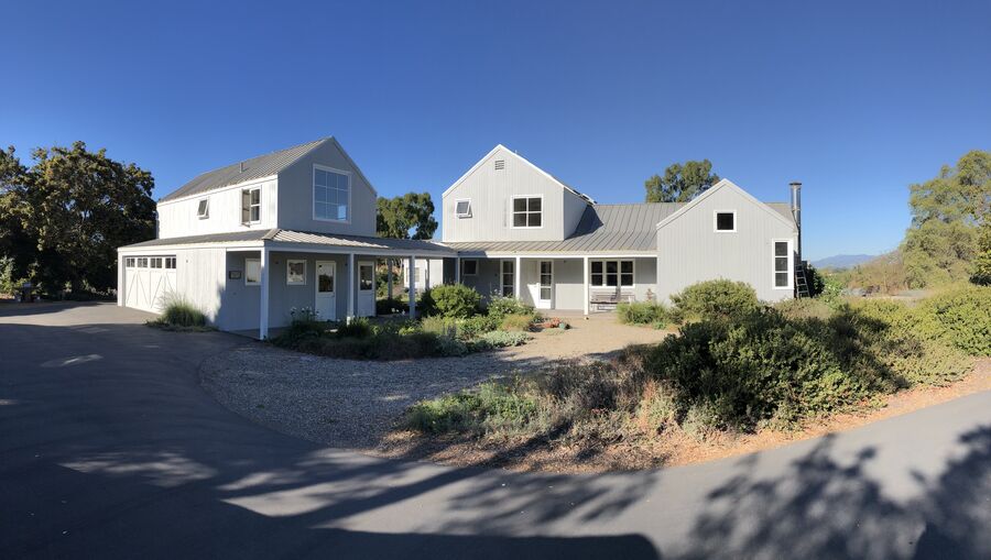 Farmhouse-style residential exterior painted in gray and white tones